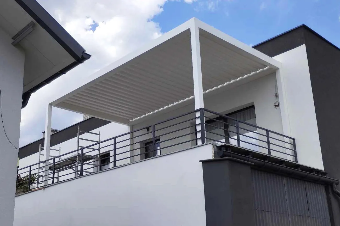 Aluminiowa pergola z ruchomym dachem lamelowym nad tarasem domu